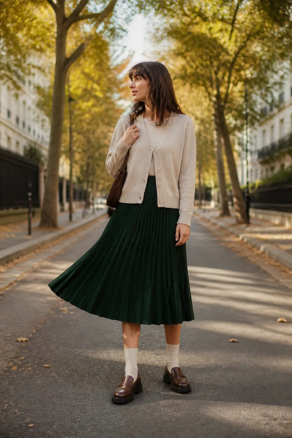 Forest-green pleated midi skirt with an oatmeal cardigan, cream socks, and chunky brown loafers